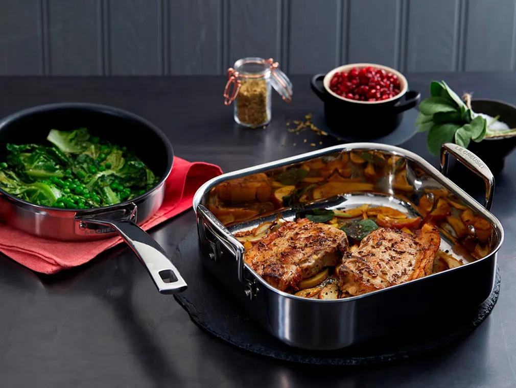 Côtes de porc en croûte de fenouil sur lit de pommes, accompagnés de petits pois braisés et laitue